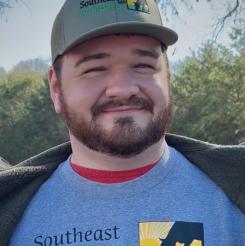 A smiling man wearing a Southeast AgriSeeds tshirt and hat